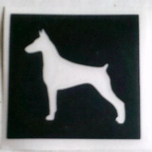 May include: A square graphic with a black background and a white silhouette of a Doberman Pinscher dog. The dog is shown in profile, standing with its legs and body clearly defined against the black.