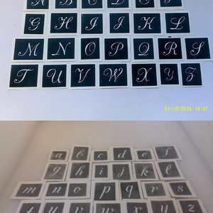 Könnte beinhalten: Zwei Sätze Alphabet-Schablonen, eine in Großbuchstaben und eine in Kleinbuchstaben. Die Schablonen sind auf weißem Papier mit schwarzer Tinte gedruckt. Die Großbuchstaben sind in einer kursiven Schriftart, während die Kleinbuchstaben in einer einfacheren Schriftart sind.