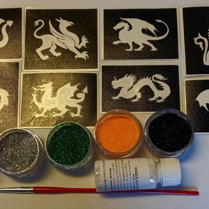 May include: A set of eight dragon stencils and five glitter pots for creating temporary tattoos. The stencils are black and white and feature different dragon designs. The glitter pots are red, silver, green, orange, and black.