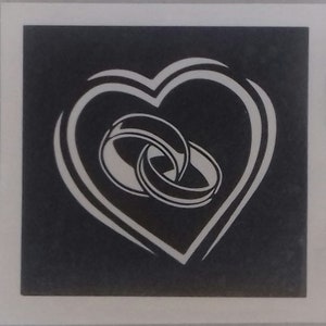 May include: A black and white image of two wedding rings intertwined inside a heart shape.