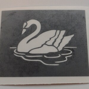 Puede incluir: Una silueta blanca de un cisne nadando en un lago, sobre un fondo gris oscuro. El cisne está mirando hacia la izquierda y tiene el cuello curvado en forma de S.