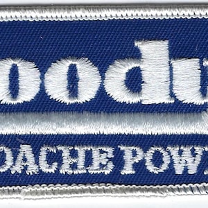 May include: A rectangular embroidered patch with a dark blue background and a white stitched border. The text Goody's is embroidered in white, with a white underline, followed by the text HEADACHE POWDERS in white capital letters below.