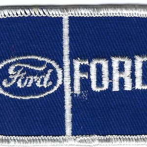 Peut inclure: Un patch en tissu bleu avec des coutures blanches. Le patch présente le logo Ford dans un cercle et le mot "FORD" en lettres blanches.
