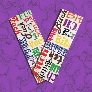 May include: Two rectangular white stickers with colorful text. One sticker has the word "FUCK" repeated in various colors. The other sticker has the word "BITCH" repeated in various colors. The stickers are on a purple background.