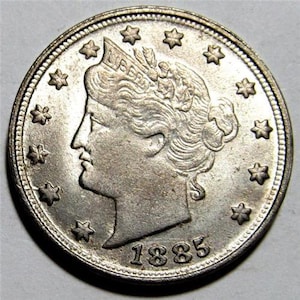 May include: Silver US half dollar coin with the profile of Liberty on the obverse. The coin has a date of 1885.
