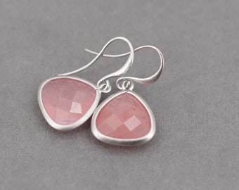 May include: A pair of silver dangle earrings with pink gemstone triangle drops.
