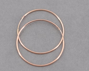 May include: A pair of rose gold hoop earrings. The earrings are simple and elegant, and they would be a great addition to any jewelry collection.
