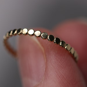 Peut inclure: Une délicate bague en or avec une rangée de petites perles rondes.