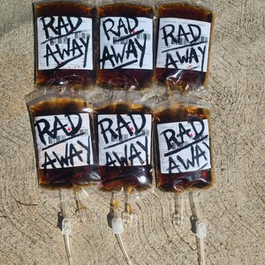Six Fallout RadAway prop bags displayed in two rows of three on cement, cosplay and display prop packs.