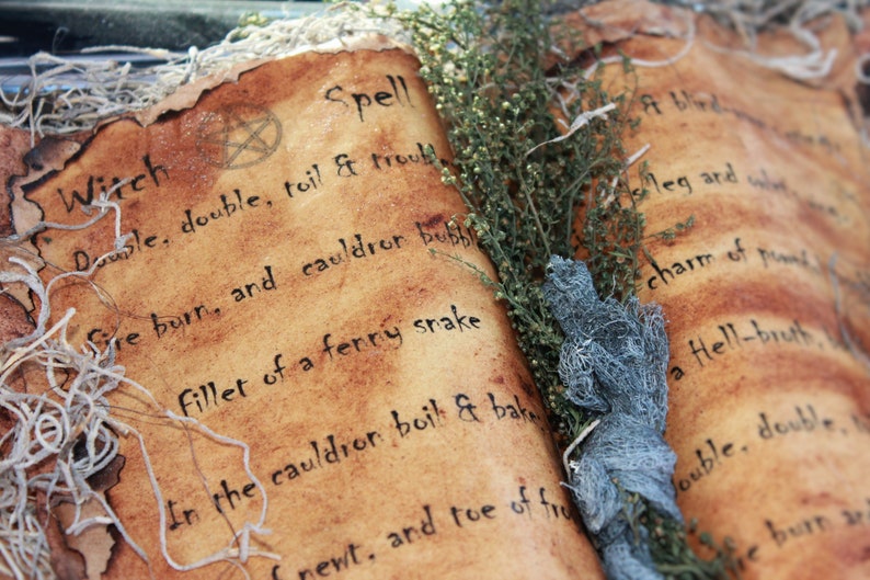 A close-up of a vintage book with a brown leather cover and a handwritten inscription that reads "Witch Spell Double, double, toil & trouble Fire burn, and cauldron bubble Fillet of a fenny snake In the cauldron boil & bake newt, and toe of frog Double, double, toil and trouble Fire burn and cauldron bubble Fillet of a fenny snake In the cauldron boil and bake newt, and toe of frog". This represents the ebooks that are included in this downloadable pack of rare witchcraft.