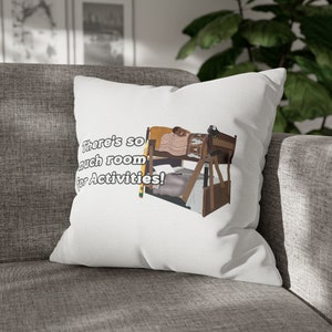 May include: White pillow with a graphic of a bunk bed with a person sleeping on the top bunk. The text on the pillow reads "There's so much room for activities!"