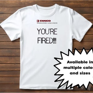 May include: White t-shirt with the text "YOU'RE FIRED!!!" in black, along with the Cusco logo. A starburst graphic states "Available in multiple colors and sizes."