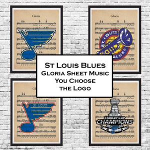 Puede incluir: Cuatro versiones diferentes del logotipo de los St. Louis Blues sobre un fondo de partitura de m&uacute;sica vintage. Los logotipos incluyen el logotipo principal del equipo, un logotipo con una trompeta, un logotipo con la Copa Stanley y un logotipo con el nombre del equipo y un palo de hockey.