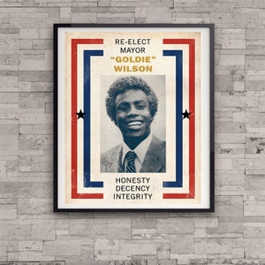 Può includere: Un manifesto di campagna politica in stile vintage con un uomo di colore sorridente con il testo "Rieletto sindaco "Goldie" Wilson" e le parole "Onestà, Decenza, Integrità" in rosso, bianco e blu.