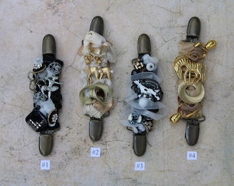 May include: Four decorative clips with different embellishments, including fabric, beads, and metal charms. The clips are numbered 1 through 4.