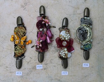 May include: Four decorative hair clips with different embellishments. The clips are numbered #13, #14, #15, and #16.  The embellishments include a butterfly, flowers, beads, and a crescent moon.