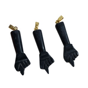 May include: Three black onyx pendants shaped like a fist with a gold bail.