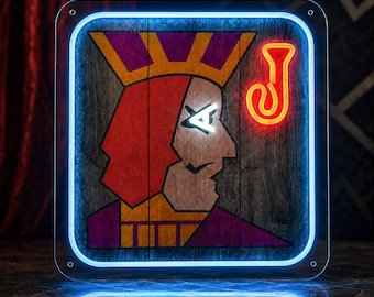 May include: A square wall sign featuring a stylized Jack playing card graphic on a wood-grain background. The design includes a red and purple figure with a crown, a bright orange neon letter J, and a glowing blue neon border frame.