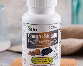 Puede incluir: Una botella blanca de suplemento dietético Sayan Chaga + Shilajit Freeze Dry Extract. La botella está etiquetada con un gráfico de hongo y el texto "Apoyo inmunológico y de la memoria".