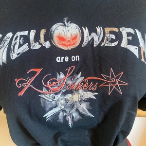 May include: Black t-shirt with a graphic print of a jack-o-lantern and the text "Halloween are on 7 Sinners".