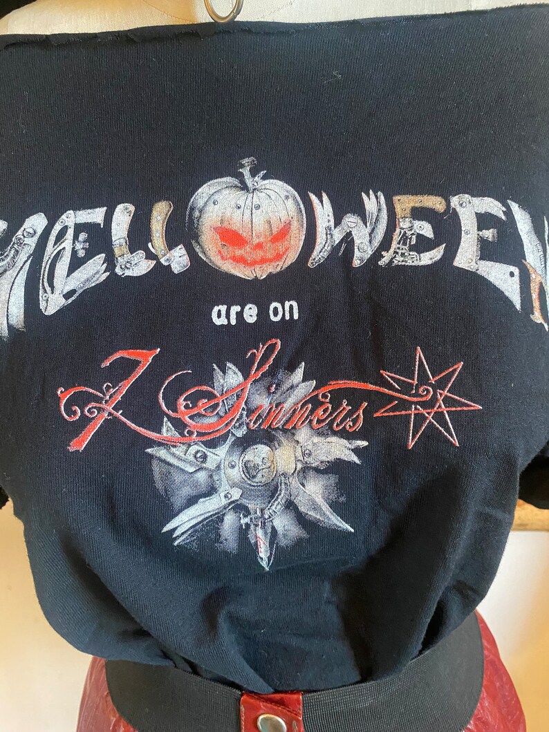 May include: Black t-shirt with a graphic print of a jack-o-lantern and the text "Halloween are on 7 Sinners".