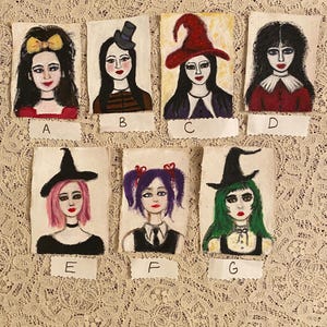 May include: Seven hand-painted portraits of women with different hairstyles and clothing. Each portrait is framed with a white border and labeled with a letter from A to G.