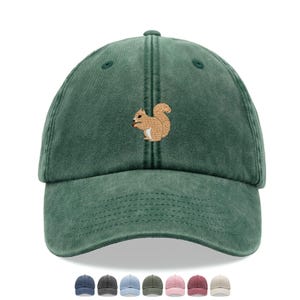 May include: A green baseball cap with a worn look. It has an embroidered squirrel motif on the front. The image also shows a selection of other cap colours at the bottom.