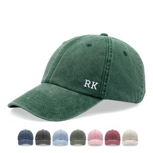 Op de afbeelding: Een groene, gewassen baseballcap van katoen met de initialen "RK" in wit geborduurd op de voorkant. De cap is te zien in verschillende kleuren, waaronder blauw, grijs, lichtblauw, donkergroen, roze, rood en beige.