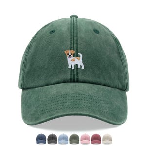 Pode incluir: Boné de beisebol verde com acabamento desgastado. Apresenta um cão Jack Russell Terrier bordado na frente. O boné tem uma aba curva e uma alça ajustável. Várias outras opções de cores são mostradas abaixo.
