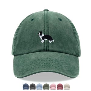 May include: A green baseball cap with a worn look. It has an embroidered black and white Border Collie dog. The cap has a curved peak and an adjustable strap. Several other colour options are shown below the cap.