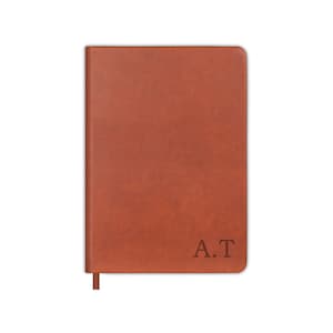 May include: A brown leather-bound journal with the initials "A.T." embossed on the front cover.