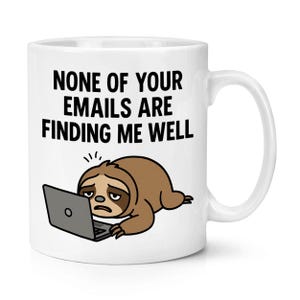 Puede incluir: Taza de cerámica blanca con el texto "NONE OF YOUR EMAILS ARE FINDING ME WELL". La taza presenta un perezoso de dibujos animados usando una computadora portátil. El perezoso es marrón con una expresión triste.