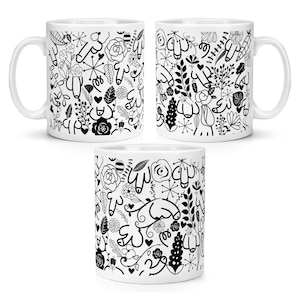 May include: White ceramic mug with a black and white floral and abstract design. The design includes flowers, leaves, and other organic shapes. The mug has a white handle and is suitable for hot or cold beverages.