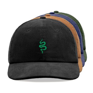 May include: A set of four corduroy baseball caps in black, brown, blue, and green. Each cap features a small embroidered green snake design.