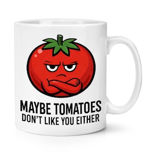 Può includere: Tazza in ceramica bianca con l'illustrazione di un pomodoro dei cartoni animati. Il pomodoro ha un'espressione arrabbiata e le braccia incrociate. Sotto il pomodoro c'è la scritta: "MAYBE TOMATOES DON'T LIKE YOU EITHER". La tazza ha un manico curvo.