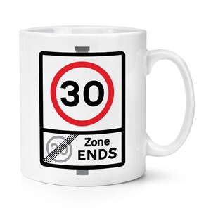 May include: White ceramic mug with a road sign design. The sign shows a red circle with the number 30, and a lower section with a speed limit sign and the words "Zone ENDS". The mug has a curved handle.