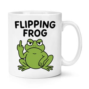 Può includere: Tazza in ceramica bianca con la scritta "FLIPPING FROG" in nero, sopra un ranocchio verde dei cartoni animati che mostra il dito medio. Il ranocchio ha un'espressione arrabbiata. La tazza ha un manico bianco.