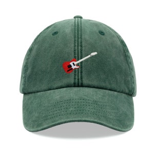 Peut inclure: Une casquette de baseball verte avec une guitare électrique rouge brodée sur le devant.