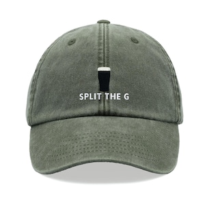 May include: An olive green baseball cap featuring an embroidered graphic of a black pint glass with a white foam head, positioned above the white embroidered text that reads SPLIT THE G, centred on the front panel of the six-panel hat.
