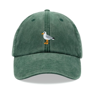 May include: A green baseball cap with an embroidered seagull design.