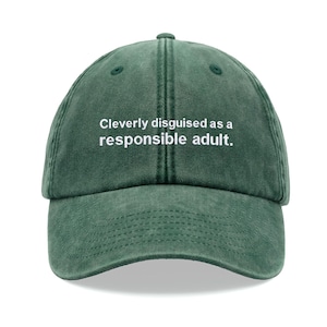 May include: A green baseball cap with the text "Cleverly disguised as a responsible adult." embroidered in white.