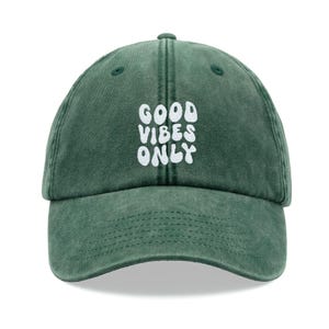 Könnte beinhalten: Eine grüne Baseballkappe mit weiß gesticktem Text, der "GOOD VIBES ONLY" lautet.