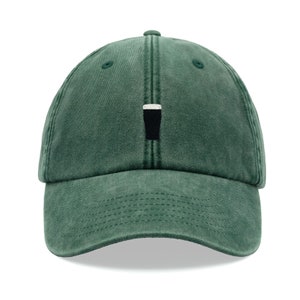 May include: A green baseball cap with a curved brim. The cap features a small, embroidered design of a black pint of beer with a white head. The hat is made of a soft, washed fabric.