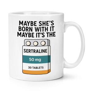 May include: White ceramic mug featuring the text "MAYBE SHE'S BORN WITH IT MAYBE IT'S THE" and a graphic of a Sertraline pill packet. The packet reads "SERTRALINE 50 mg 30 TABLETS".