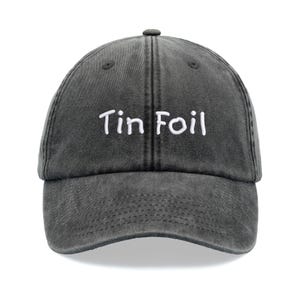 Puede incluir: Una gorra de béisbol de algodón negro lavado con texto bordado en blanco que dice "Tin Foil".