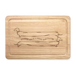 May include: A wooden chopping board with a dachshund silhouette and the text "Dachshund body of a sausage, heart of a lion".
