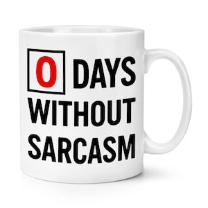 Op de afbeelding: Witte keramische mok met de tekst "0 DAYS WITHOUT SARCASM" in het zwart, met het cijfer "0" in een rode kader. De mok heeft een gebogen oor en is geschikt voor warme of koude dranken.
