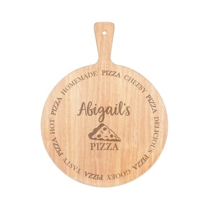 Puede incluir: Una tabla redonda de madera para cortar pizza con asa. La tabla está grabada con las palabras "Homemade Pizza Cheesy Pizza Delicious Pizza Tasty Pizza Gooey Pizza" y "Abigail's Pizza".