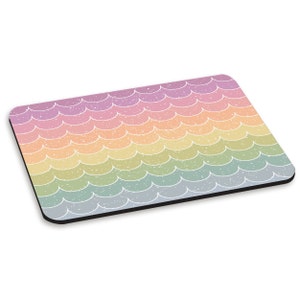 Könnte beinhalten: Ein regenbogenfarbenes Mauspad mit einem Muster aus weißen Schuppen. Das Mauspad hat einen schwarzen Rand.