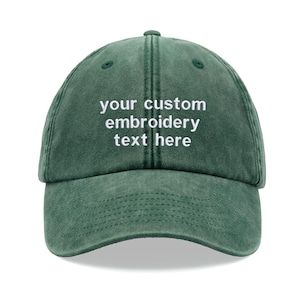 Op de afbeelding: Een donkergroene, gewassen baseballcap van katoen met witte borduurwerk dat "your custom embroidery text here" luidt.